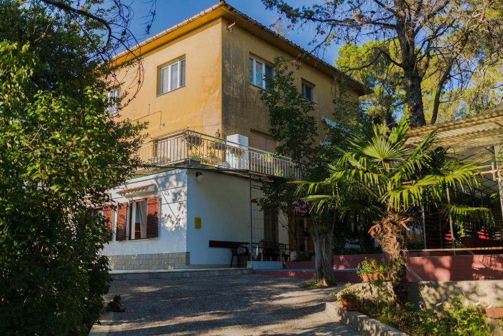 stary dom z balkonem i drzewem w obiekcie Apartment Maestral near the Beach w mieście Malinska