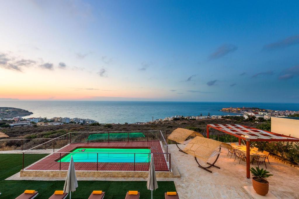 a view of a swimming pool and the ocean at Villa Princess in Rethymno Town