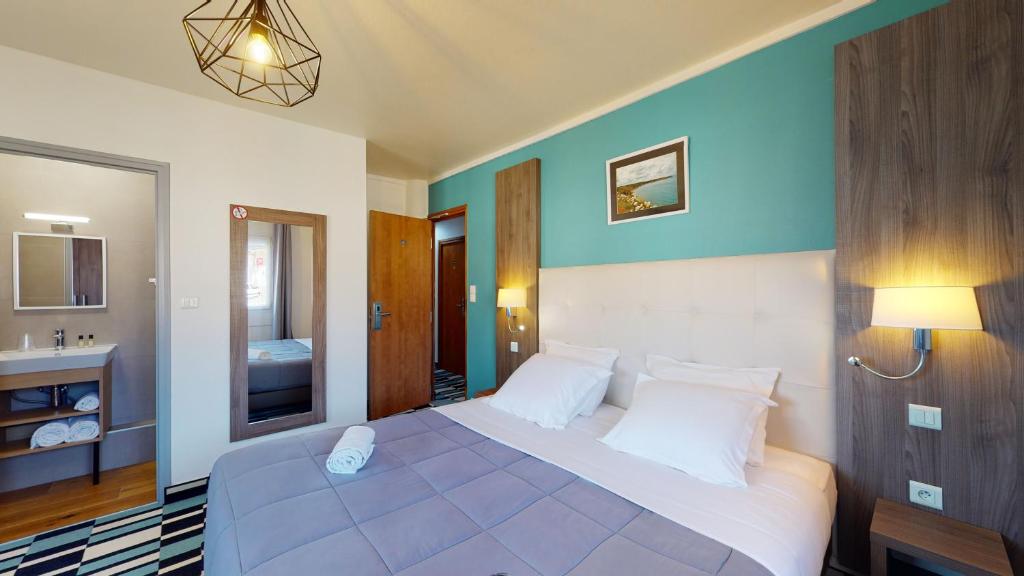 Postel nebo postele na pokoji v ubytování Hôtel Les Pieux En Cotentin