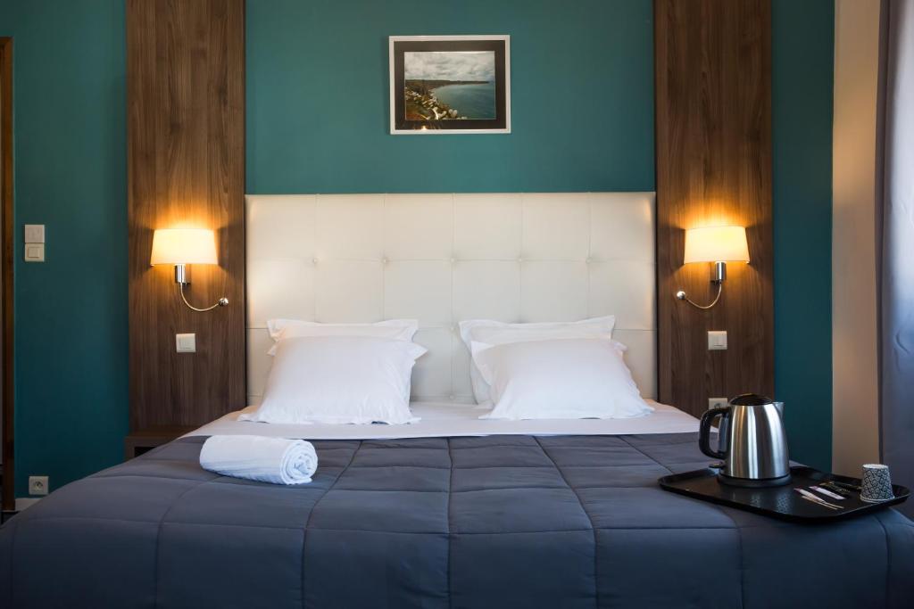 Un pat sau paturi într-o cameră la Hôtel Les Pieux En Cotentin