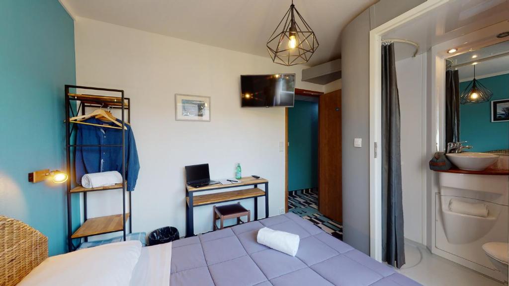 Postel nebo postele na pokoji v ubytování Hôtel Les Pieux En Cotentin