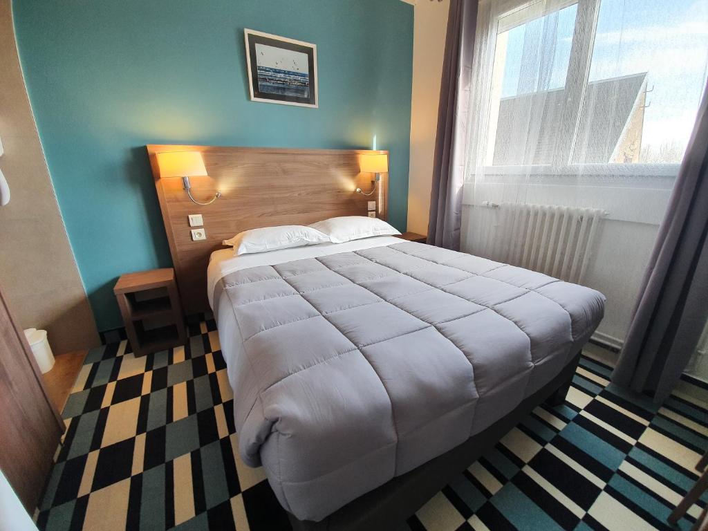 Postel nebo postele na pokoji v ubytování Hôtel Les Pieux En Cotentin