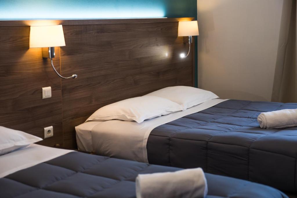 Postel nebo postele na pokoji v ubytování Hôtel Les Pieux En Cotentin