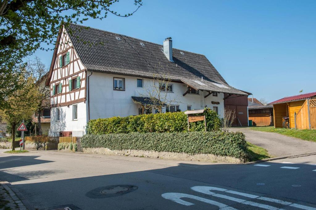 una casa bianca seduta sul lato di una strada di Ferienwohnung Auer a Überlingen