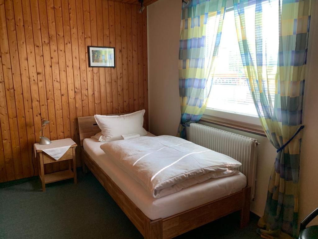 a small bedroom with a bed and a window at Hotel Garni Siedlerstube in Nürtingen