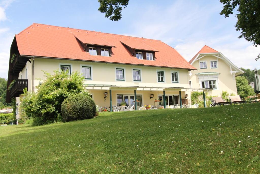una casa grande con techo naranja en Landhaus Strussnighof, en Pörtschach am Wörthersee