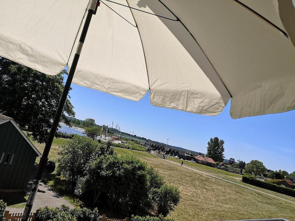 a close up of a white umbrella in a field at Meeresblick-Strandkoerbchen Haus 2 , WE 19 in Hohwacht