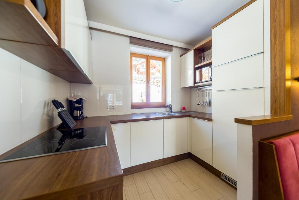 a kitchen with white cabinets and a sink and a window at Sissi Park in Lachtal