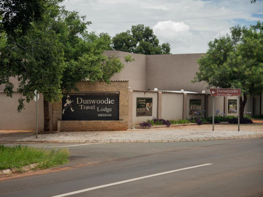 a building with a sign on the side of a street at Dunwoodie Travel Lodge in Pretoria