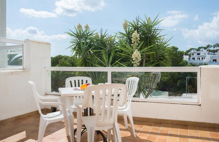 un tavolo bianco e sedie sul balcone di Apartamento Playa Dor 14 a Cala d´Or