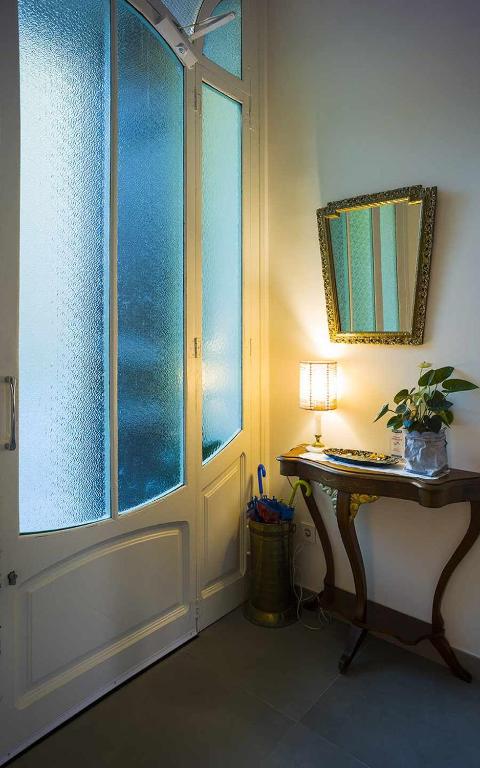 a room with a window and a table with a lamp at Cal Peó B&B Cardedeu in Cardedeu