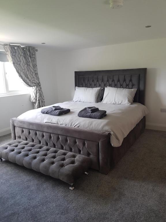 a bedroom with a large bed with a tufted headboard at Brendan's Apartment On Same Grounds As Family Home in Armoy