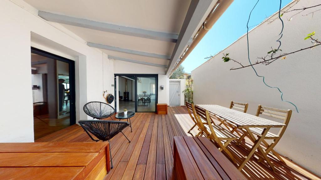 Cette chambre dispose d'une terrasse en bois avec une table et des chaises. dans l'établissement La Bonne Brise - Superbe loft avec terrasse à 2 minutes de la plage, à Marseille