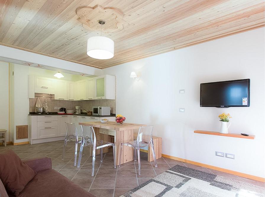 een woonkamer met een tafel en een keuken bij Villa Edelweiss in Alleghe