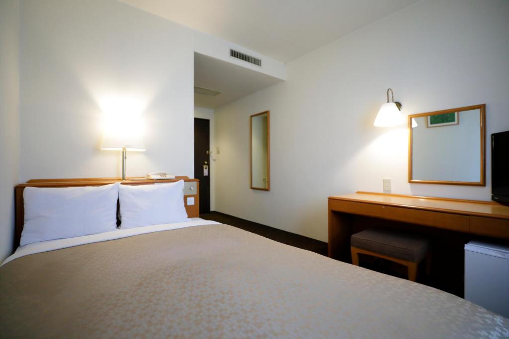 Postel nebo postele na pokoji v ubytování Kawasaki Central Hotel