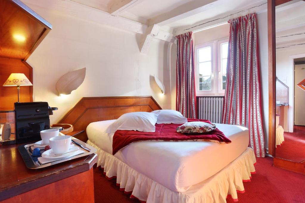史特拉斯堡的住宿－Hotel Suisse，配有一张床和一张桌子及托盘的酒店客房