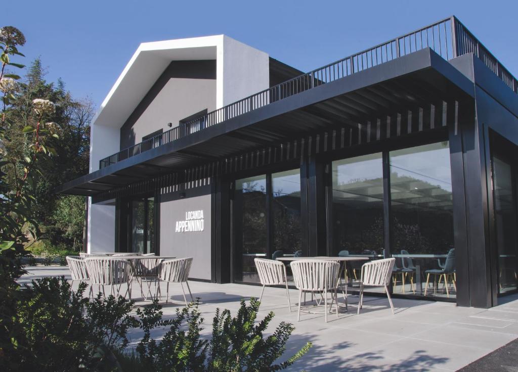 un patio con sillas y mesas frente a un edificio en Locanda Appennino, en Predappio