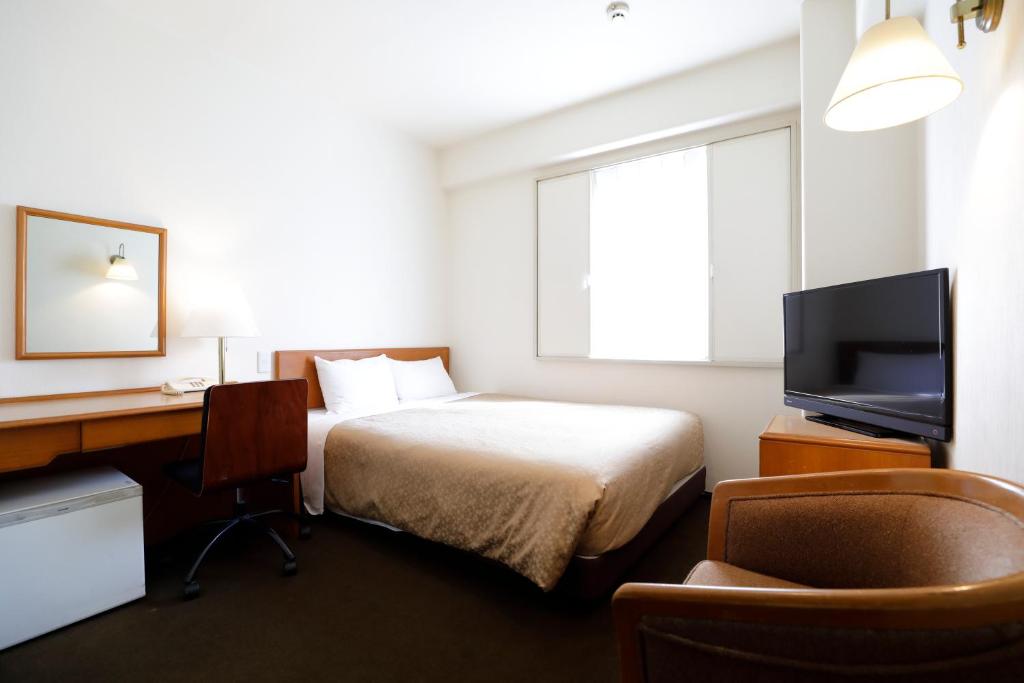 Postel nebo postele na pokoji v ubytování Kawasaki Central Hotel