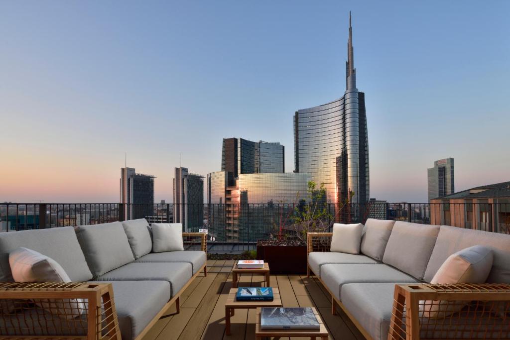 a rooftop patio with couches and a view of a city at Milano Verticale | UNA Esperienze in Milan