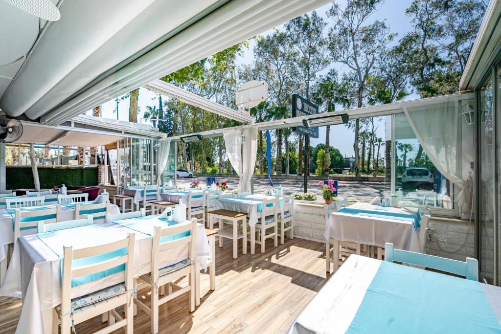 a restaurant with blue and white tables and chairs at Sare Beach Hotel in Antalya