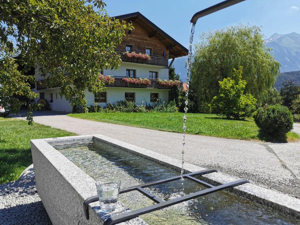 a water fountain in front of a house at Zauscherhof in Wildermieming