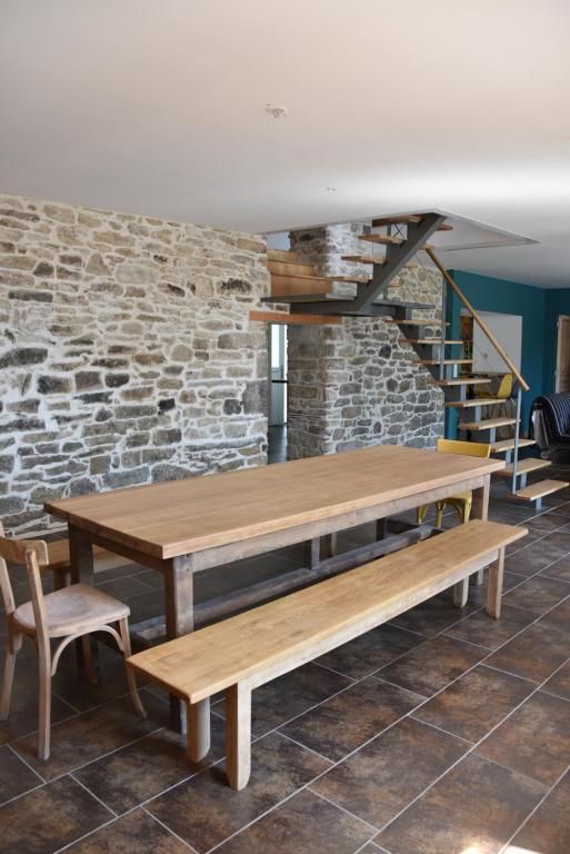 una mesa y sillas en una habitación con una pared de ladrillo en La Plooz, en Plozévet