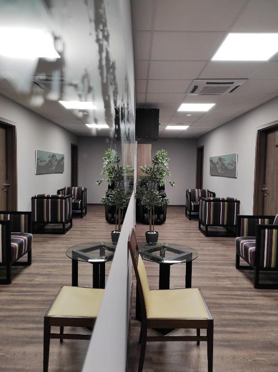 poczekalnia ze stołami, krzesłami i doniczkami w obiekcie Waterfront Lodge w mieście Dunapataj