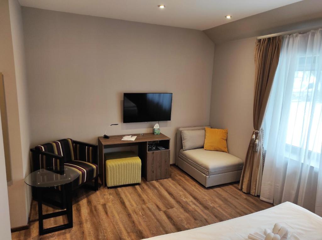 Pokój hotelowy z telewizorem, biurkiem i krzesłem w obiekcie Waterfront Lodge w mieście Dunapataj