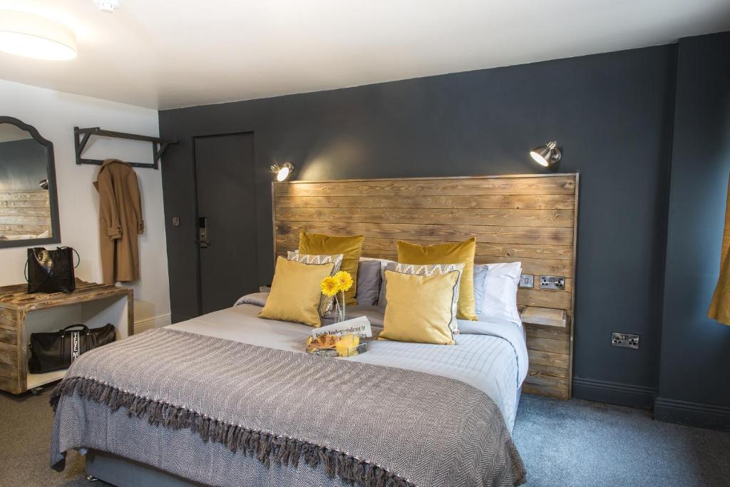 Schlafzimmer mit einem großen Bett mit einem Kopfteil aus Holz in der Unterkunft Tipperary House Dublin in Dublin