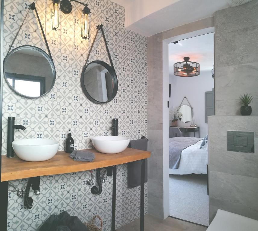 a bathroom with two sinks and a bedroom at Villa Otivar in Otívar