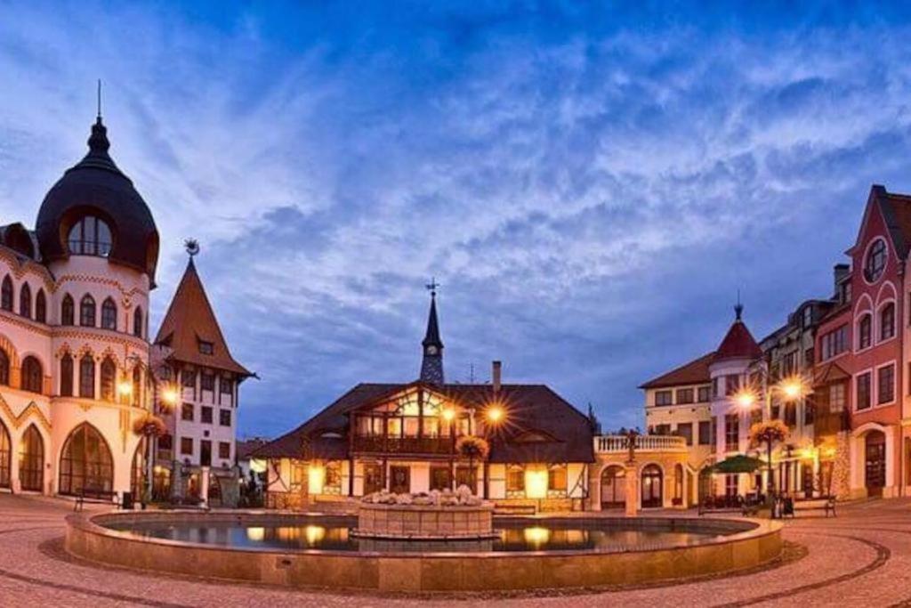 ein Stadtplatz mit einem Brunnen vor den Gebäuden in der Unterkunft Apartmán Zara in Komárno