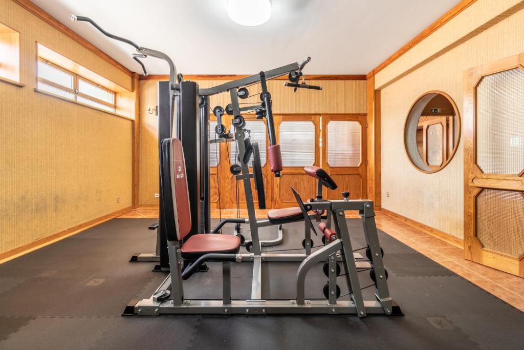 a gym with cardio equipment in a room at Hotel Colmeia in Monte Real