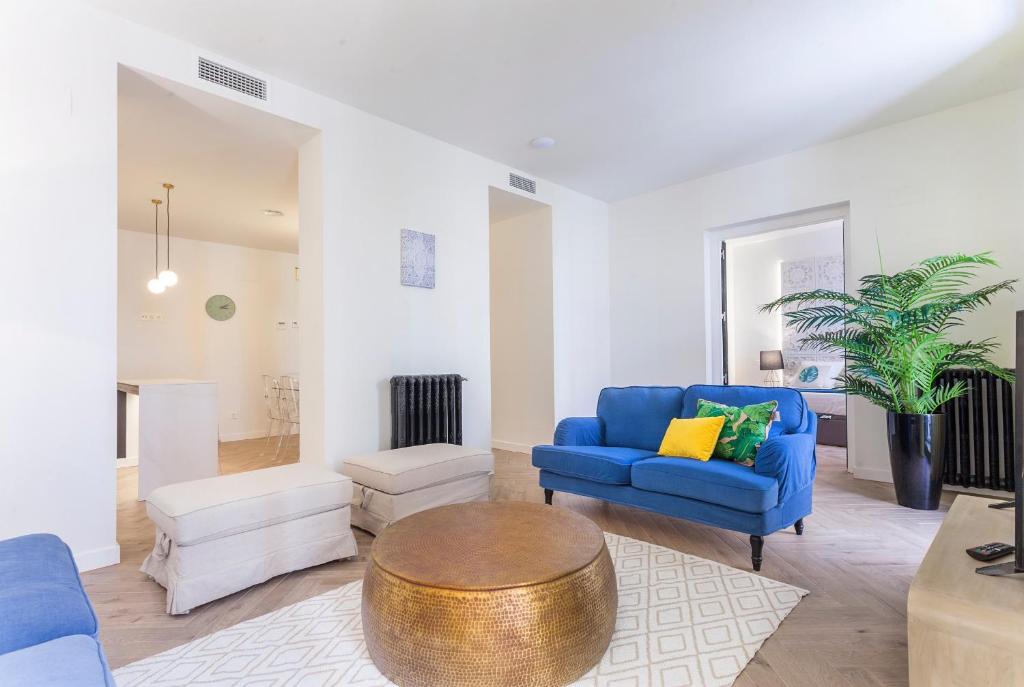 een woonkamer met een blauwe bank en een tafel bij Zoko Suites en Madrid in Madrid