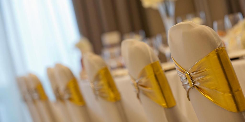a row of white chairs with yellow backs at Crowne Plaza Aberdeen Airport by IHG in Dyce