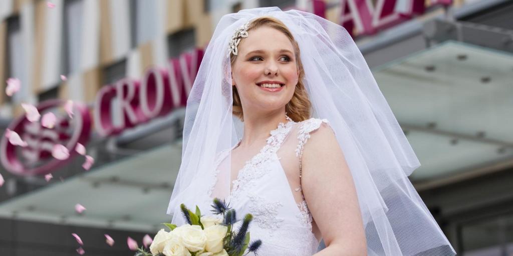 a bride wearing a veil and holding a bouquet at Crowne Plaza Aberdeen Airport by IHG in Dyce