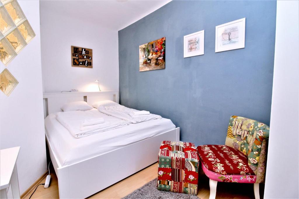 um pequeno quarto com uma cama e uma cadeira em Gorgeous Hideout | City Center Apartment em Viena