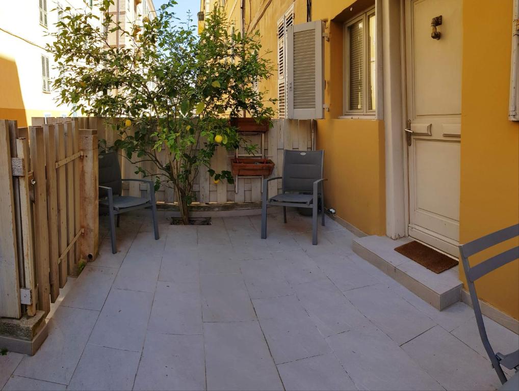 a patio with two chairs and a building at Studio centre ville in Ajaccio