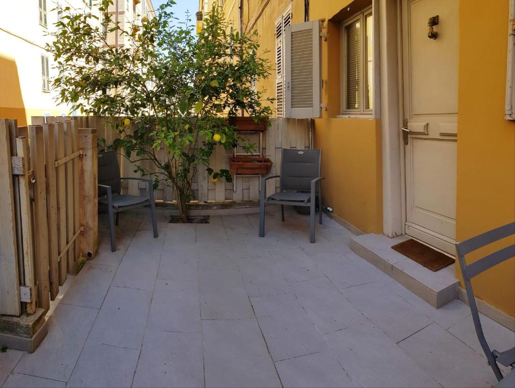 un patio avec deux chaises et un bâtiment dans l'établissement Studio centre ville, à Ajaccio
