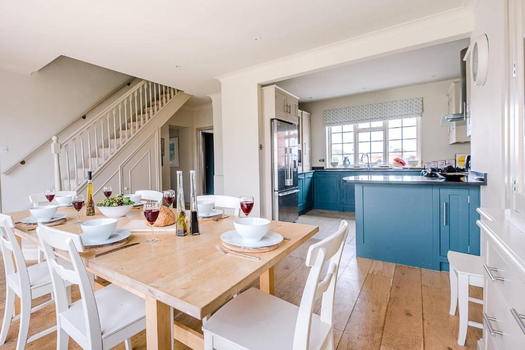 a kitchen and dining room with a wooden table and chairs at 3 The Coastguards Thorpeness Air Manage Suffolk in Leiston