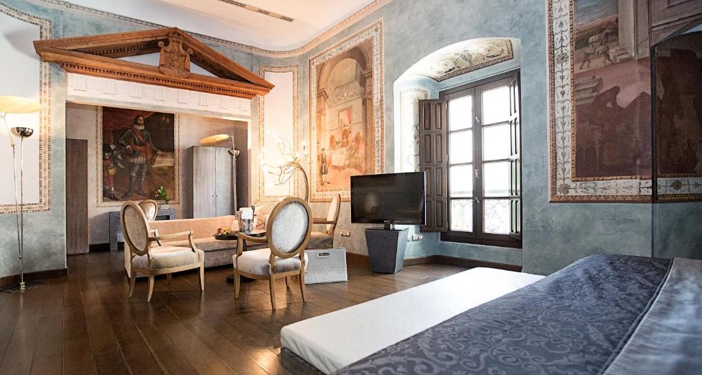 a bedroom with a bed and a table and chairs at Hospes Palacio del Bailio, a Member of Design Hotels in Córdoba
