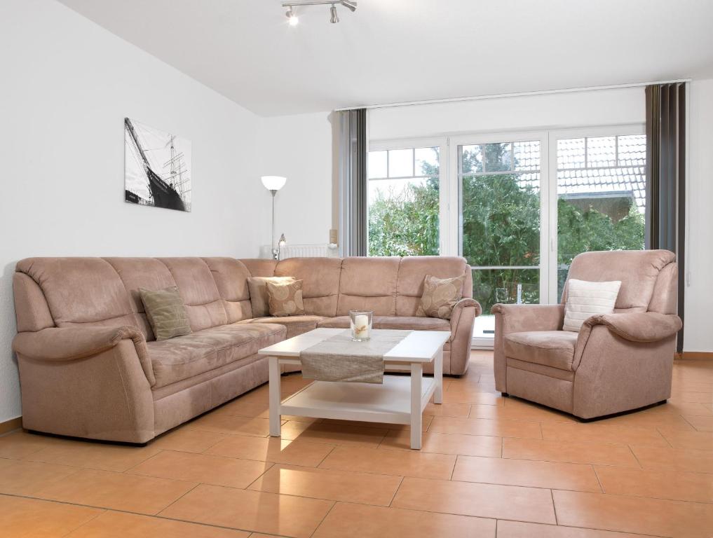 インゼル・ペールにあるReihenhäuser Timmendorf Strand Haus Sonnenaufgangのソファと椅子2脚とテーブルのあるリビングルーム