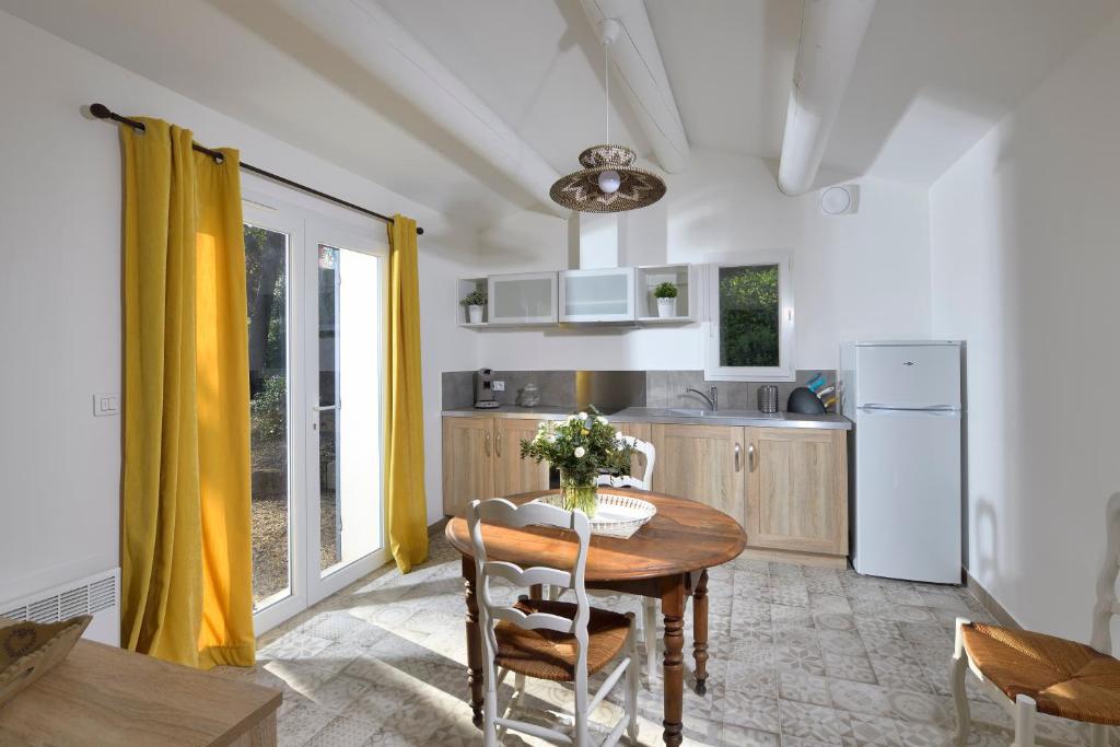 a kitchen with a wooden table and a dining room at Les Mazets de Marie de Jules in Eyragues