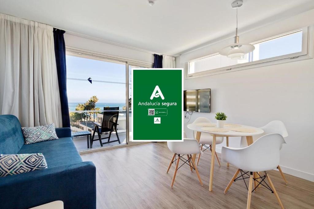 a living room with a table and a green sign at Carihuela Suites in Torremolinos
