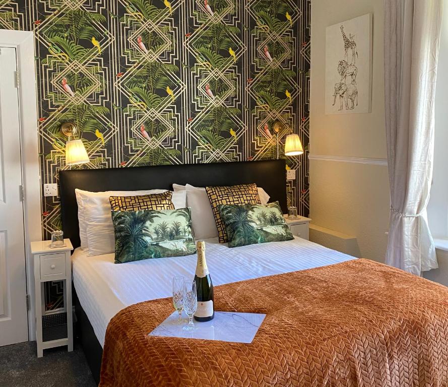 a bedroom with a bed with a bottle of wine on it at St John's Guest House in Weymouth