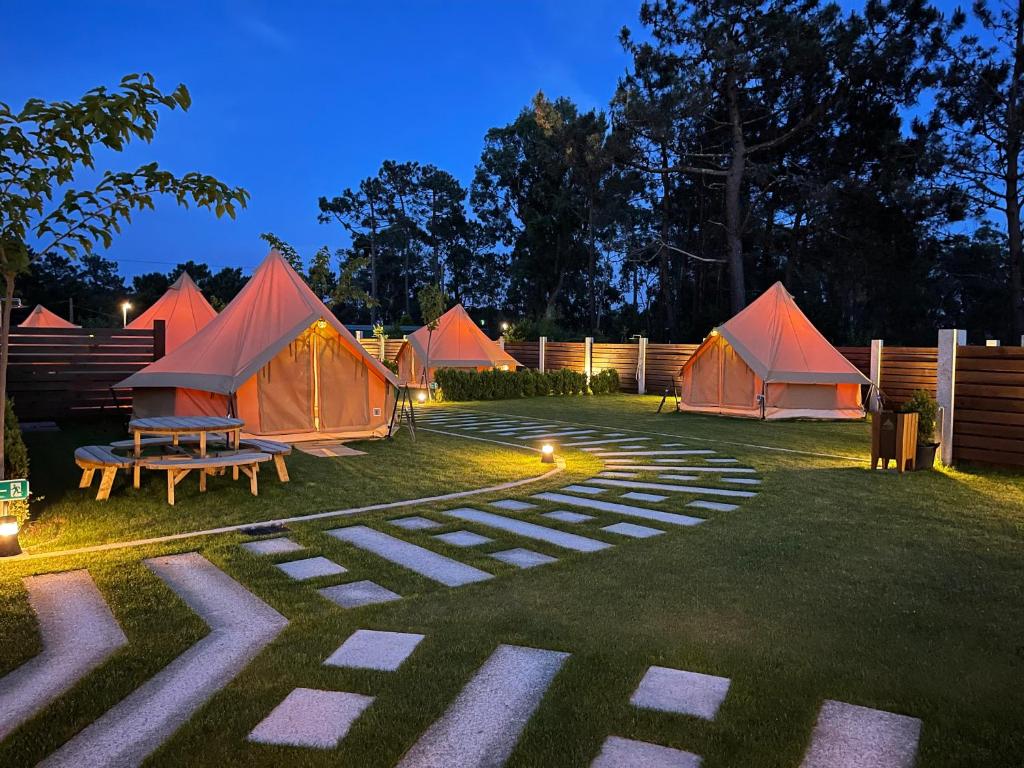 a group of tents in a yard at night at Glamping Illa de Arousa in Isla de Arosa