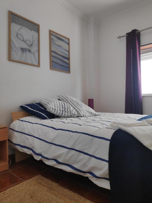 a bedroom with a bed with a blue and white blanket at Casa do Mar in Figueira da Foz
