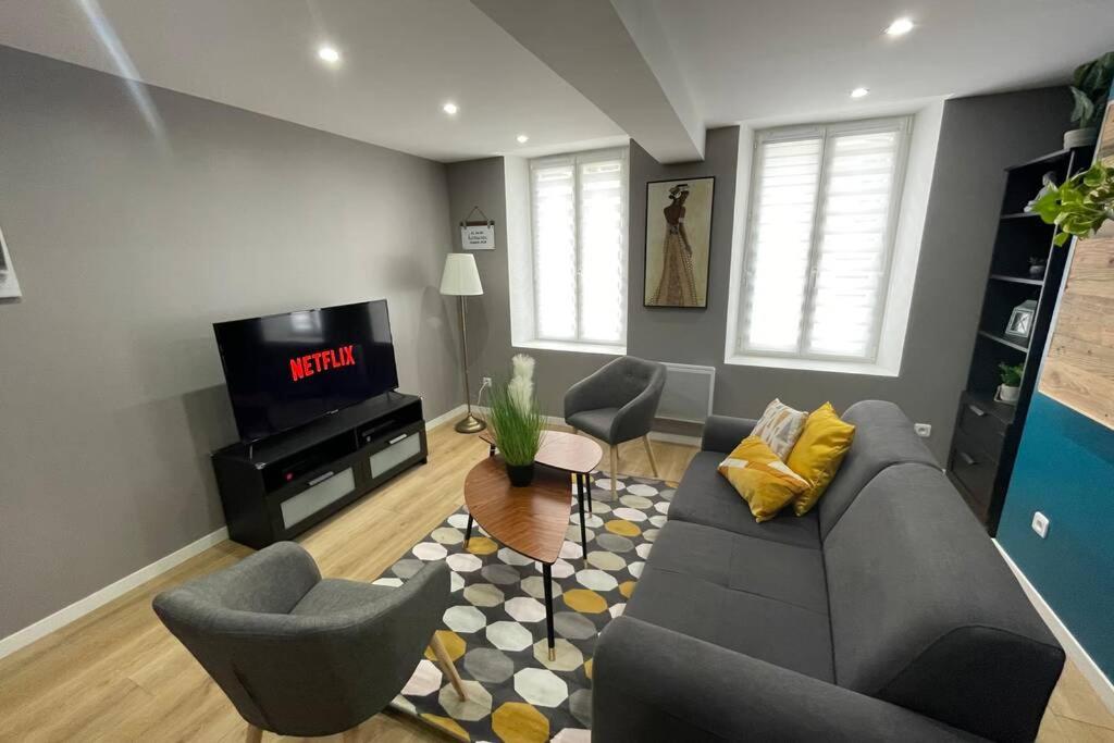 un salon avec un canapé, des chaises et une télévision dans l'établissement Appartement cosy, wifi gratuit,5 min de la gare, à Boulogne-sur-Mer