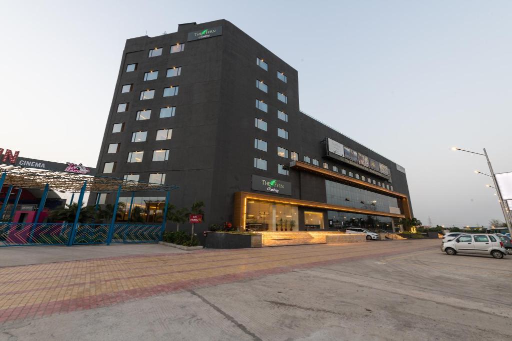 贾姆讷格尔The Fern Residency, Jamnagar的一栋黑色建筑，前面停着一辆汽车