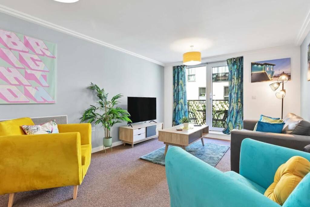a living room with blue and yellow furniture and a tv at Central Garden View -By My Getaways in Brighton & Hove