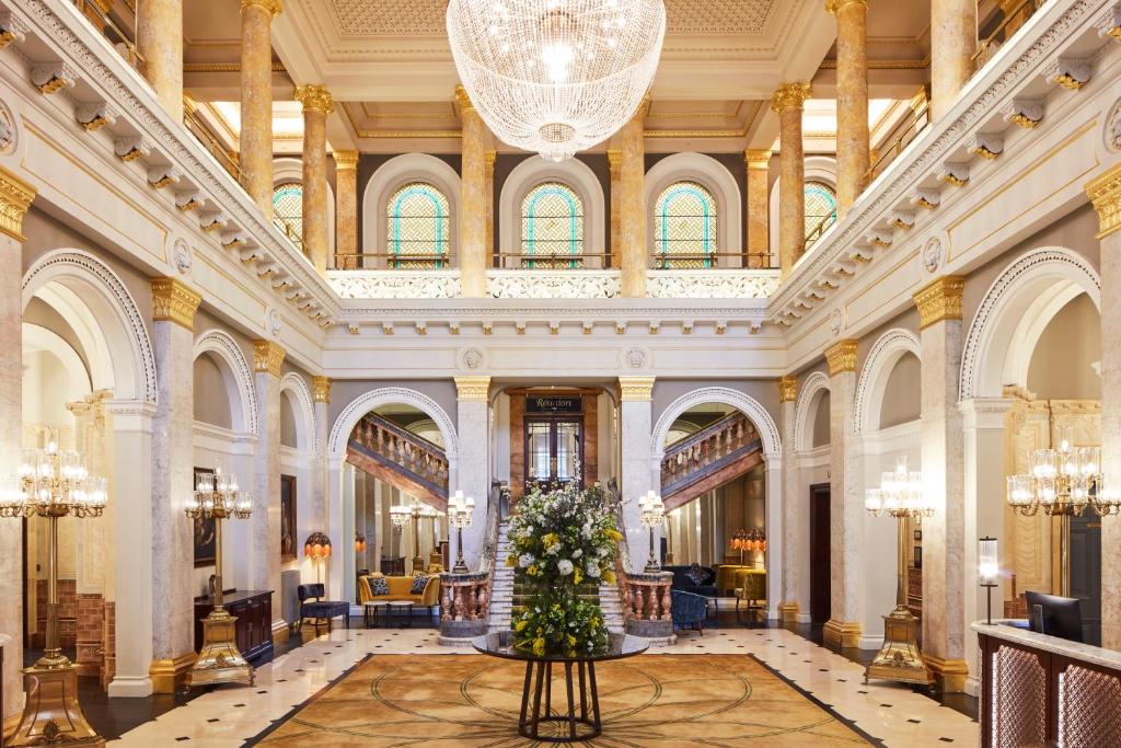 a large lobby with a christmas tree in the middle at The Clermont London, Victoria in London